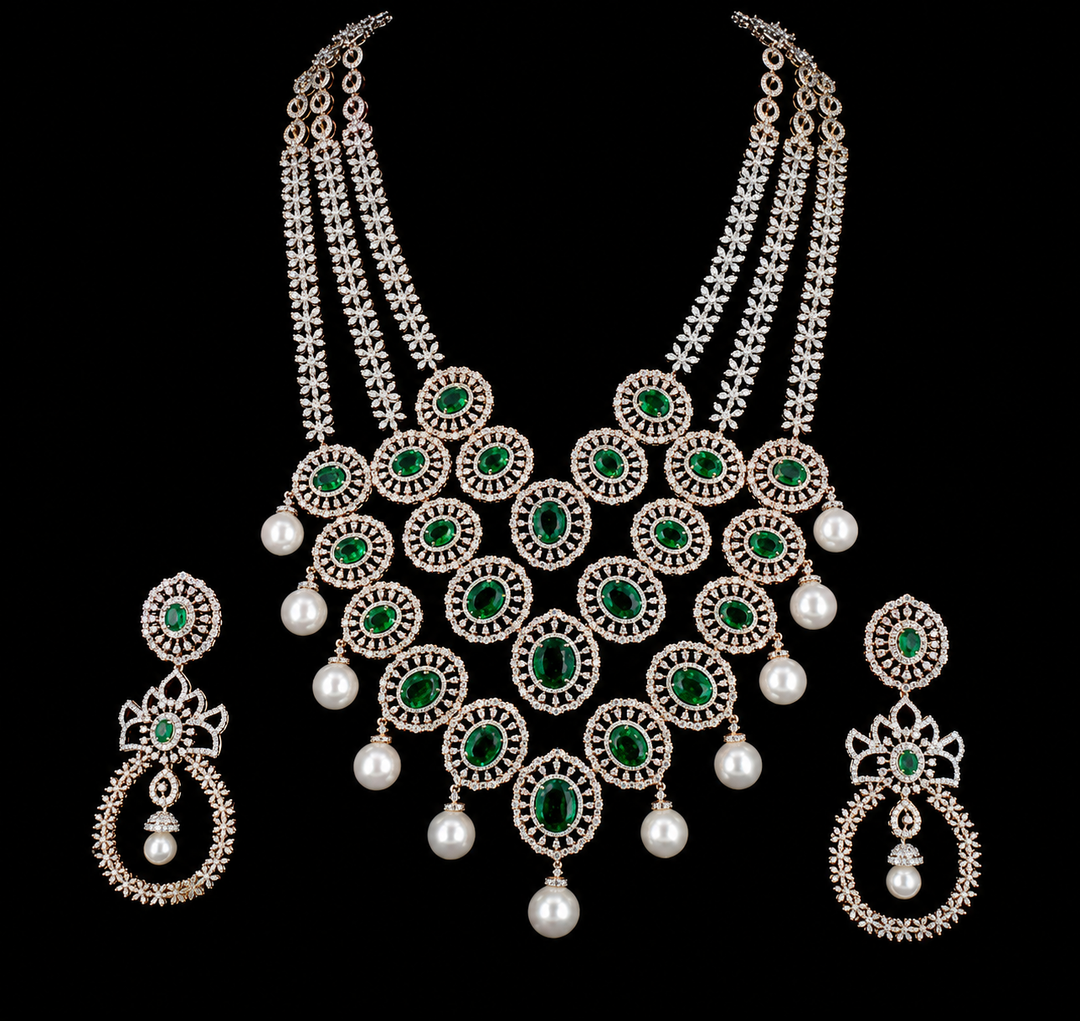 A traditional Indian Kundan necklace set with matching earrings, featuring green emerald-cut stones, white pearl drops, and intricate silver-toned filigree work, displayed against a solid black background.