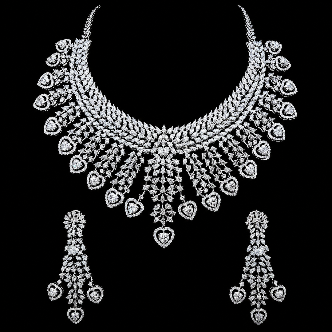 A silver-toned jewelry set featuring a wide collar necklace and two matching drop earrings, both heavily embellished with heart-shaped and floral motifs, displayed against a solid black background.